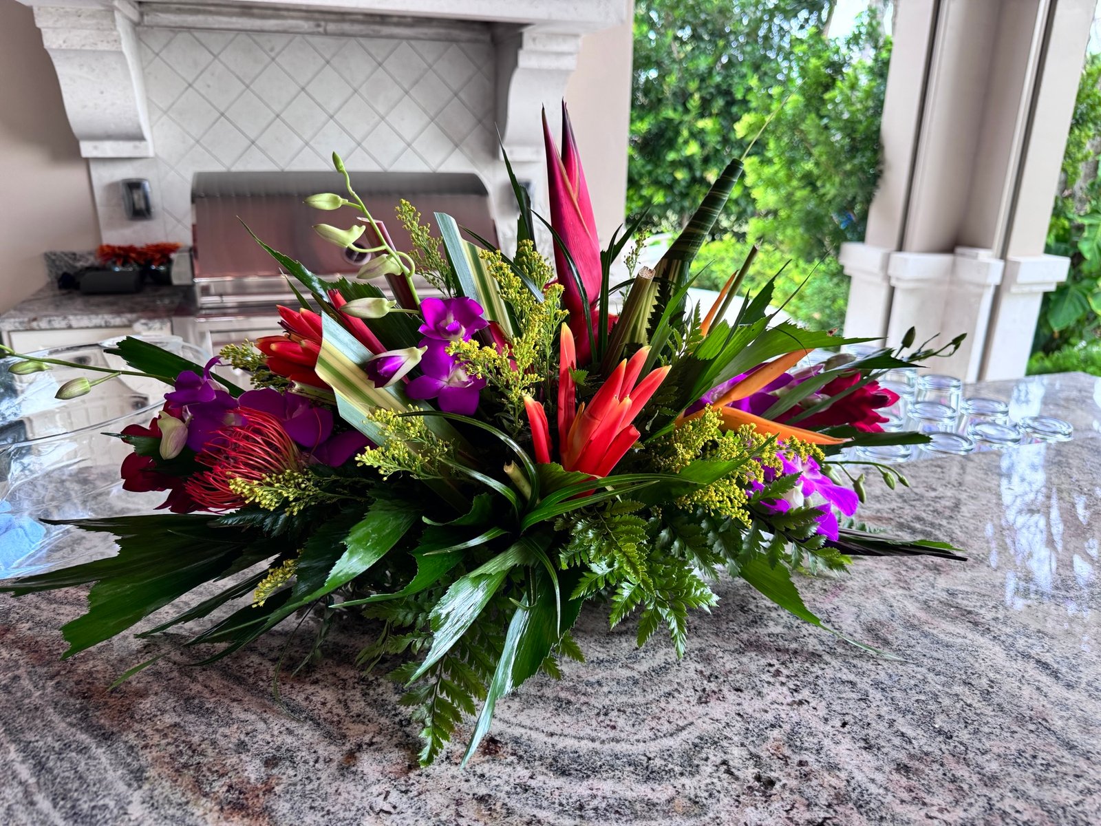 Tropical event centerpiece with orchids, bird-of-paradise, protea, and greenery