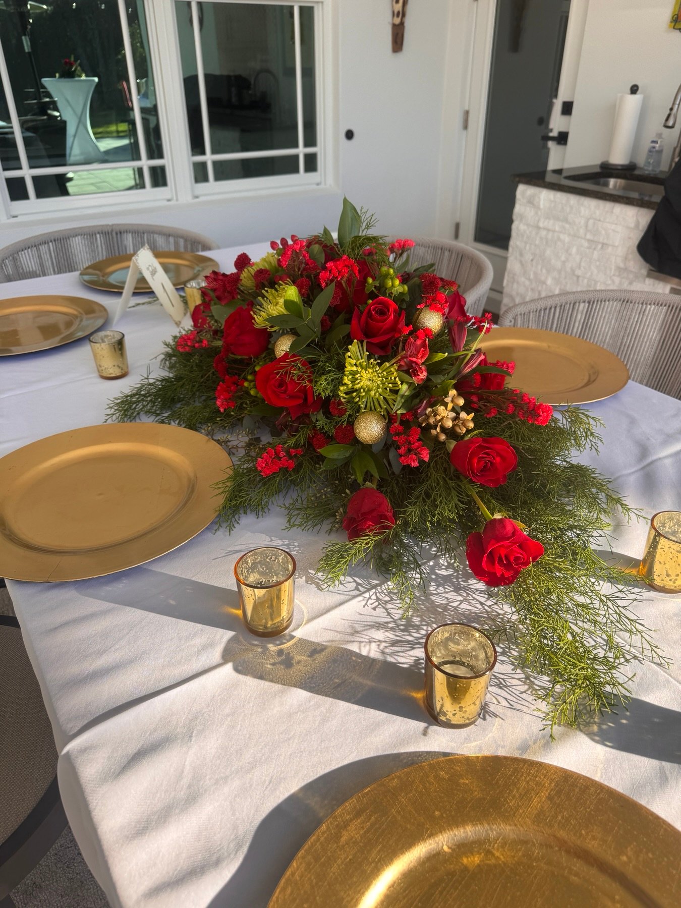 Formal red and green floral tablescape with gold place settings